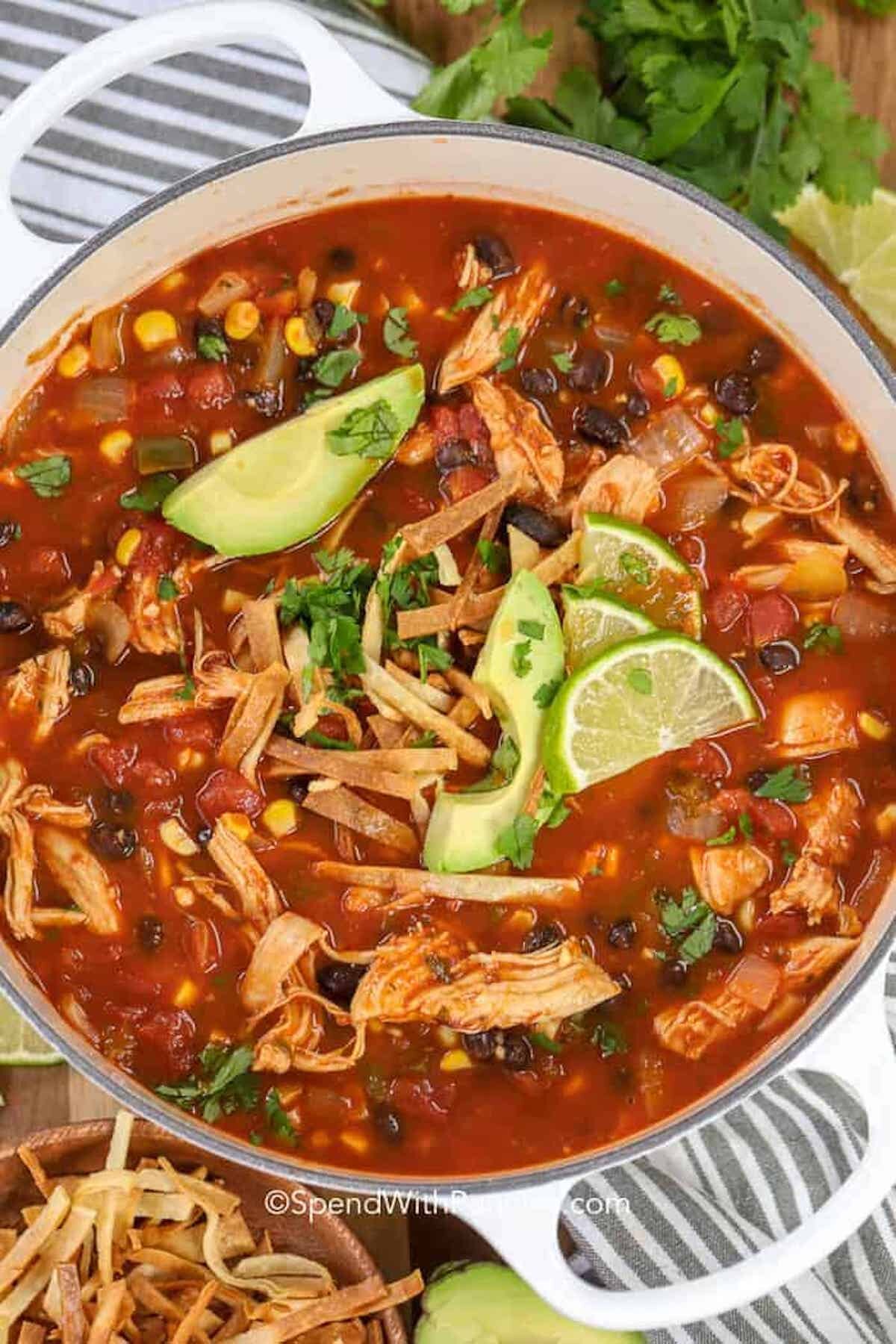 a pot of chicken tortilla soup garnished with lime