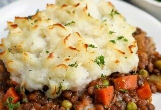 lentil shepherds pie on a plate with parsley on top