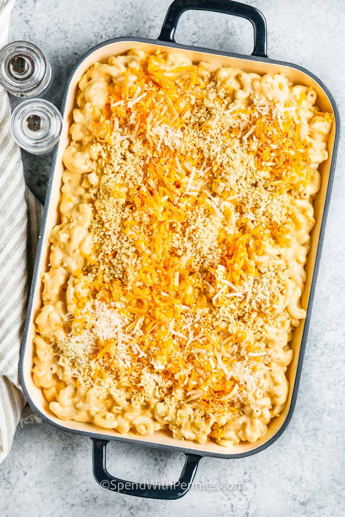 adding cheese to dish to make Baked Mac and Cheese